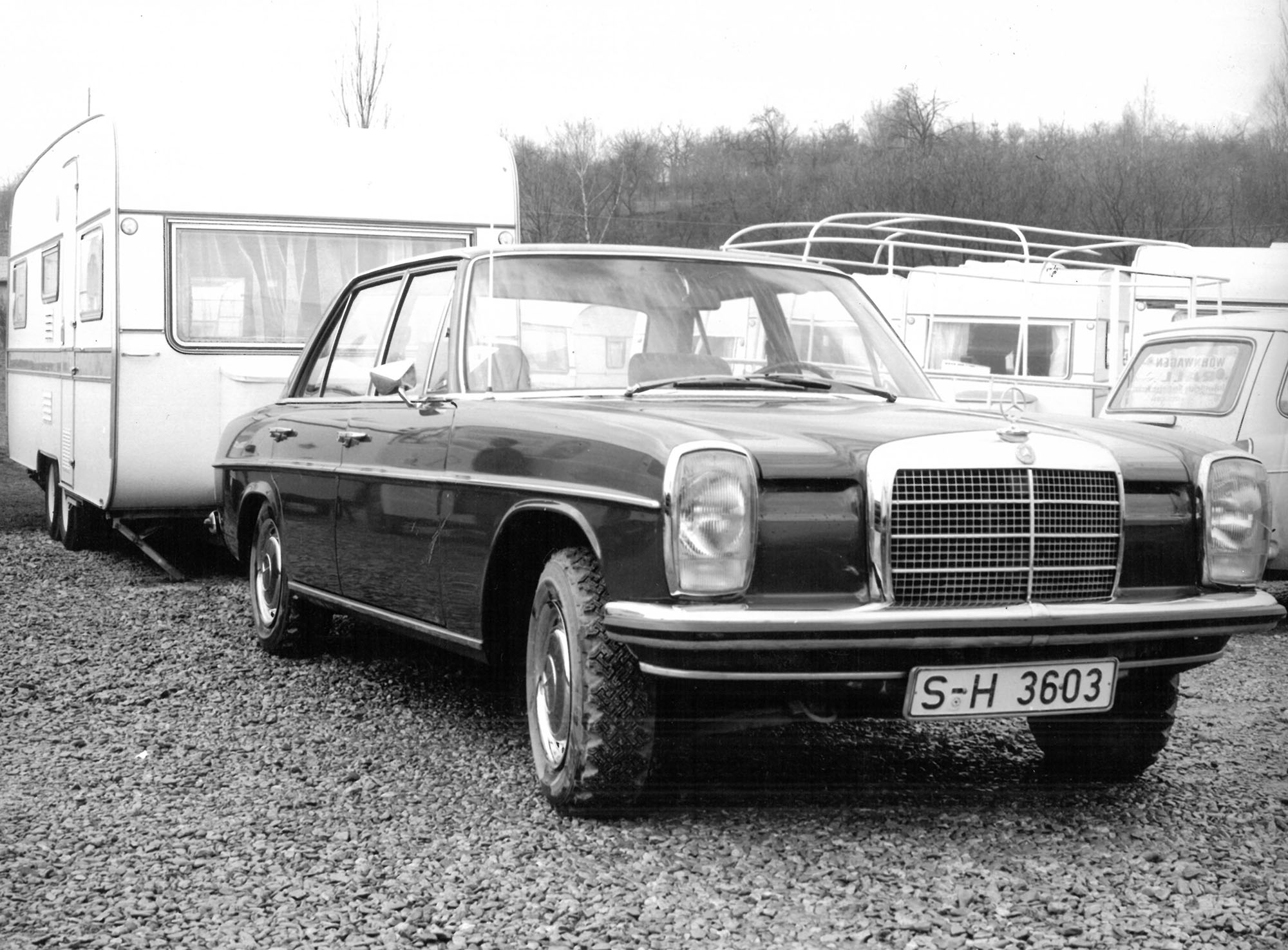 Historic black-and-white photograph of a Mercedes sedan towing a caravan, illustrating early towing applications with trailer coupling technology.