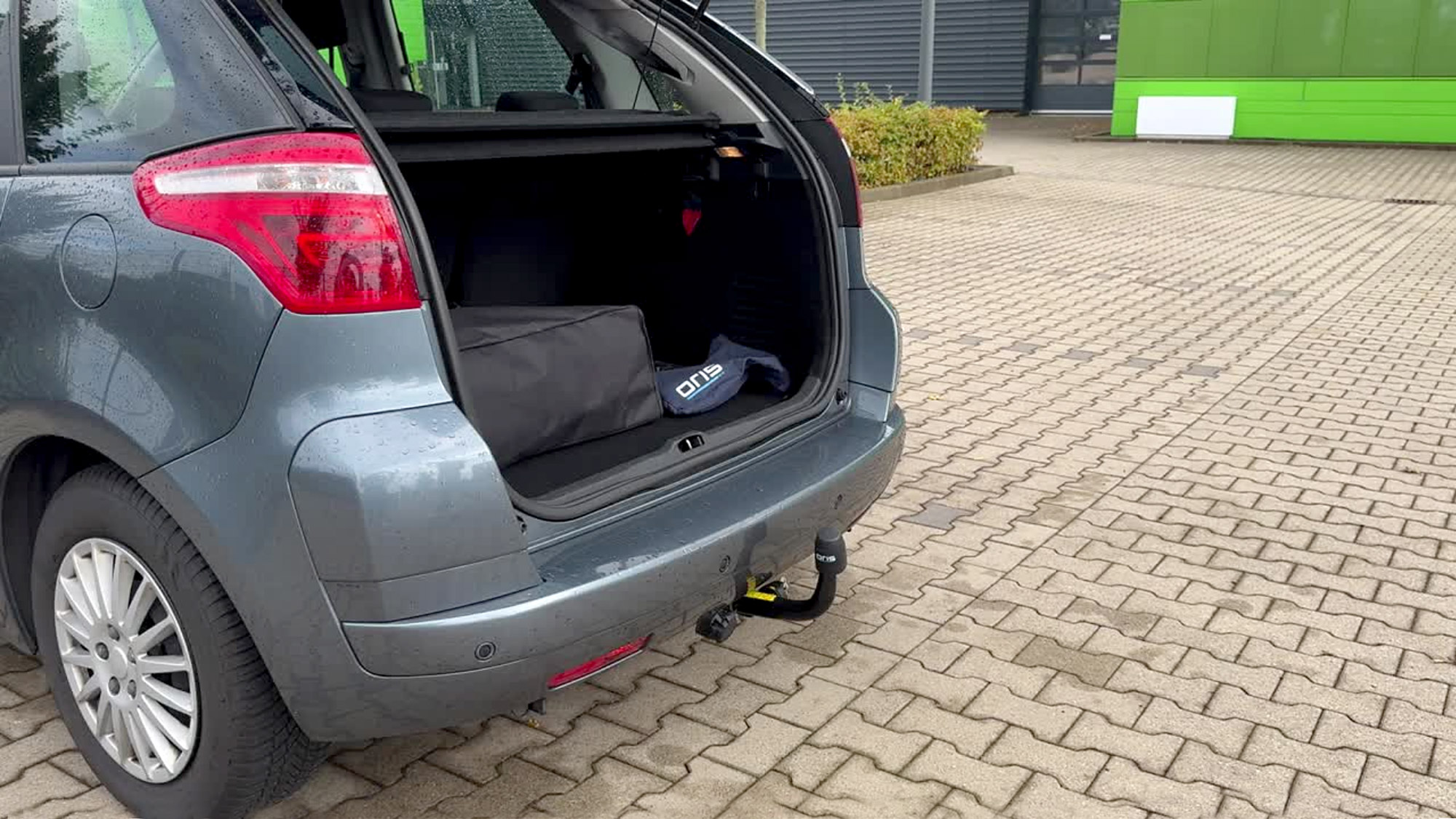 Citroën vehicle with an open tailgate and an ORIS detachable towbar featuring a horizontal removable towball.