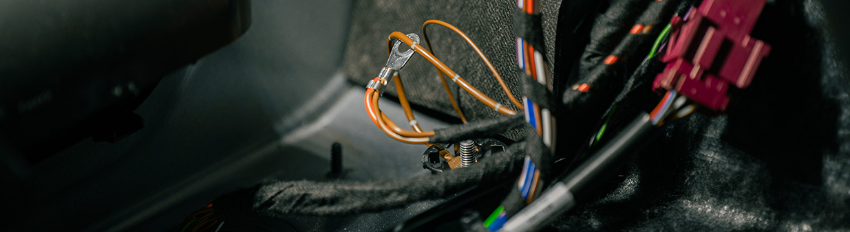 Close-up of vehicle-specific wiring and electrical connectors used in an ORIS DUO complete towbar retrofit kit.