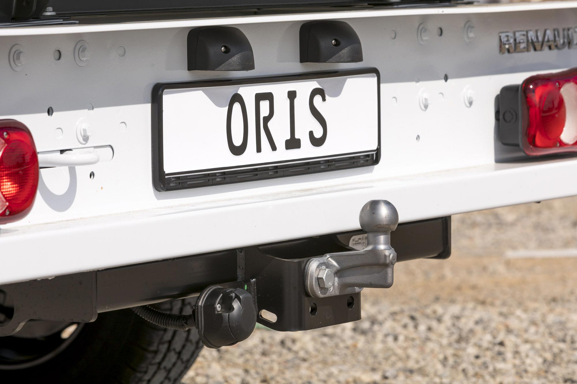 Close-up of an ORIS flanged towbar with fixed towball and electrical socket mounted on the rear of a Renault truck.